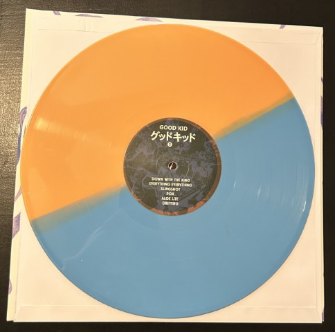 Sides A and B of the Good Kid vinyl in a bright blue and orange.